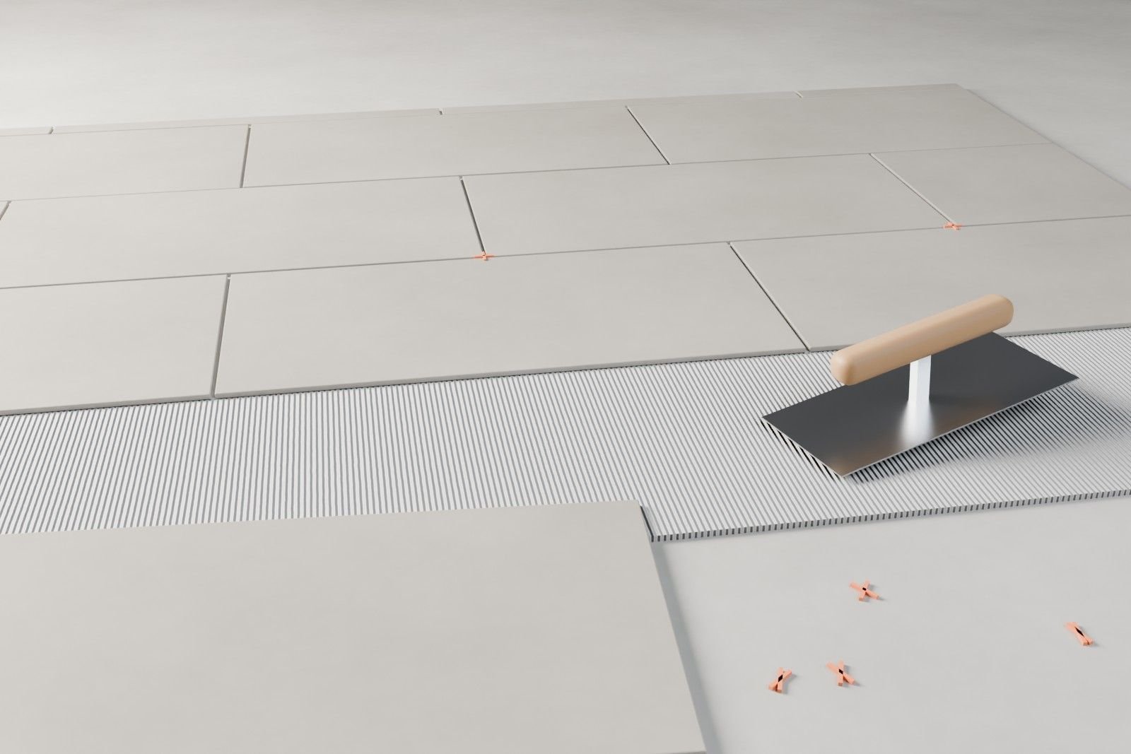 Nahaufnahme einer Baustelle: frisch verlegte Bodenfliesen, Fliesenkreuze und eine Zahnkelle im Fliesenkleber